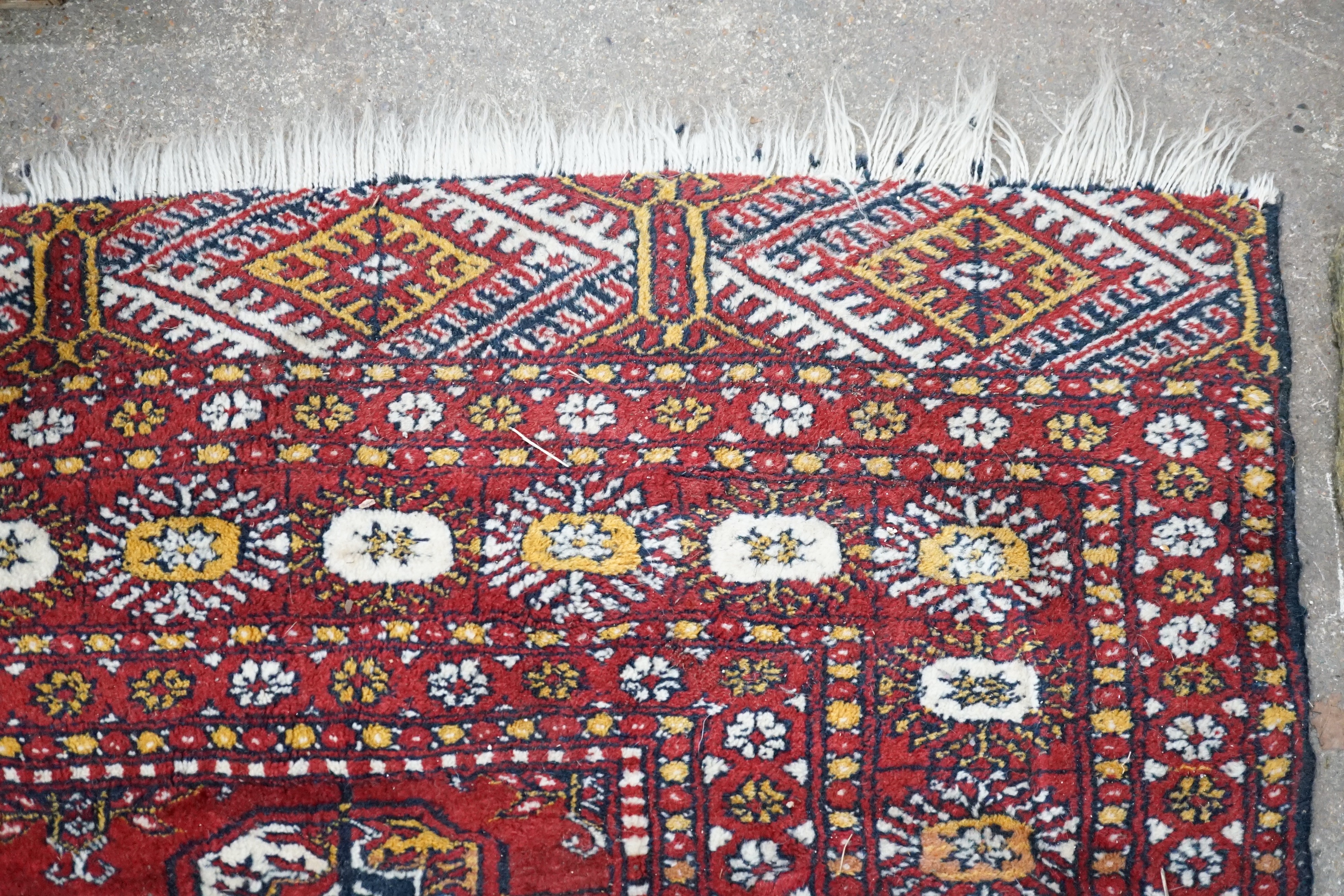 A Bokhara red ground rug, 186 x 122cm